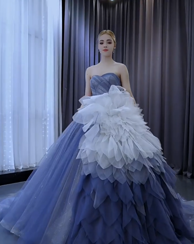 Front view of a custom blue to white ombre tulle ball gown with layered ruffles and handmade dress details Front view of a custom blue to white ombre tulle ball gown with layered ruffles and handmade dress details