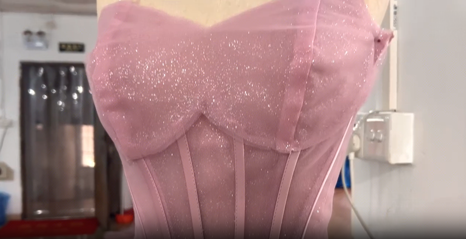 Dressmaker pinning tulle layers onto a mannequin