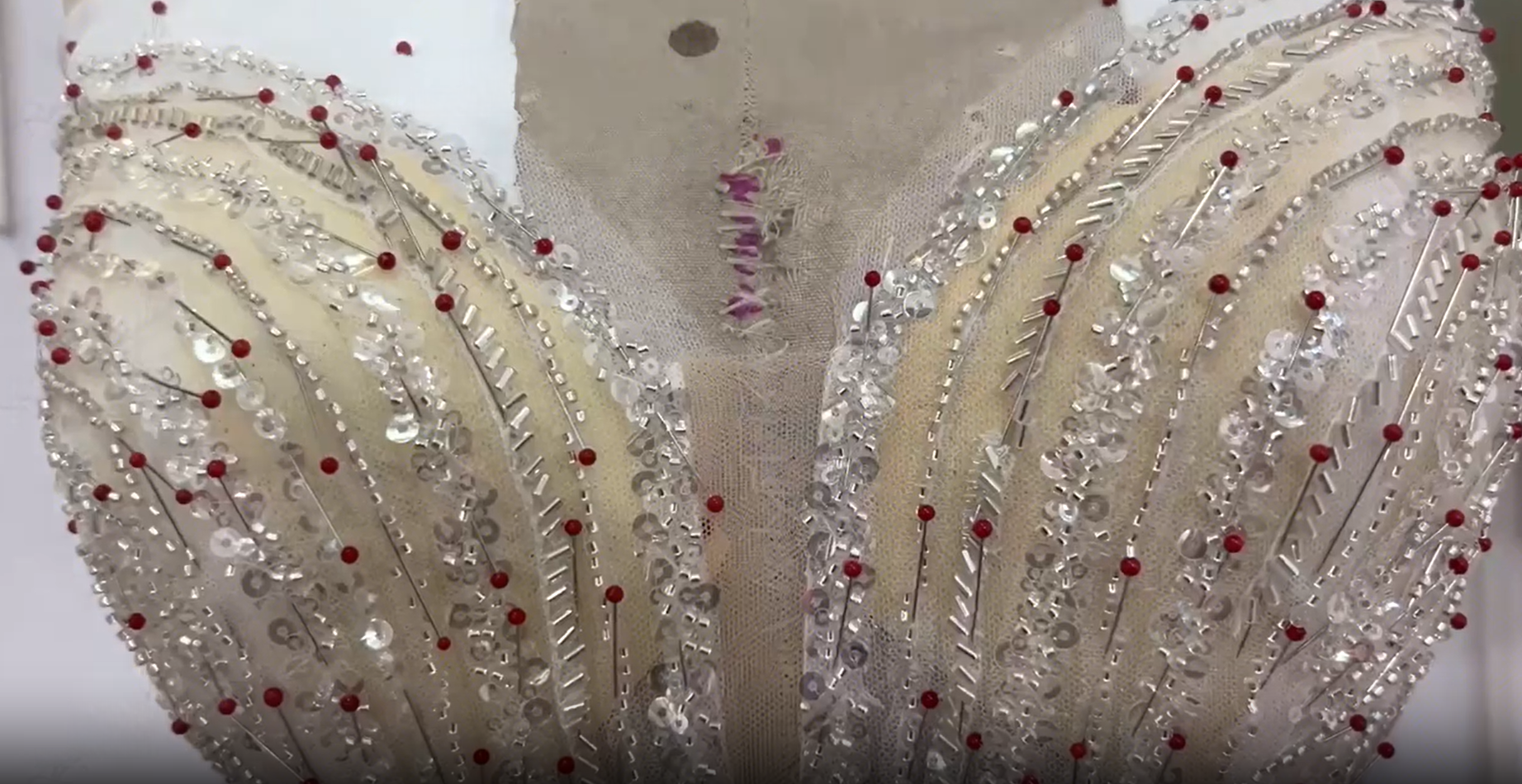 Seamstress attaching silver sequin strips to the mermaid wedding dress bodice Seamstress attaching silver sequin strips to the mermaid wedding dress bodice
